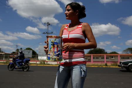 An aunt of Eliannys Vivas collects money to pay a loan used for the funeral of Eliannys, who died from diphtheria, along a main street in Pariaguan, Venezuela January 26, 2017. REUTERS/Marco Bello