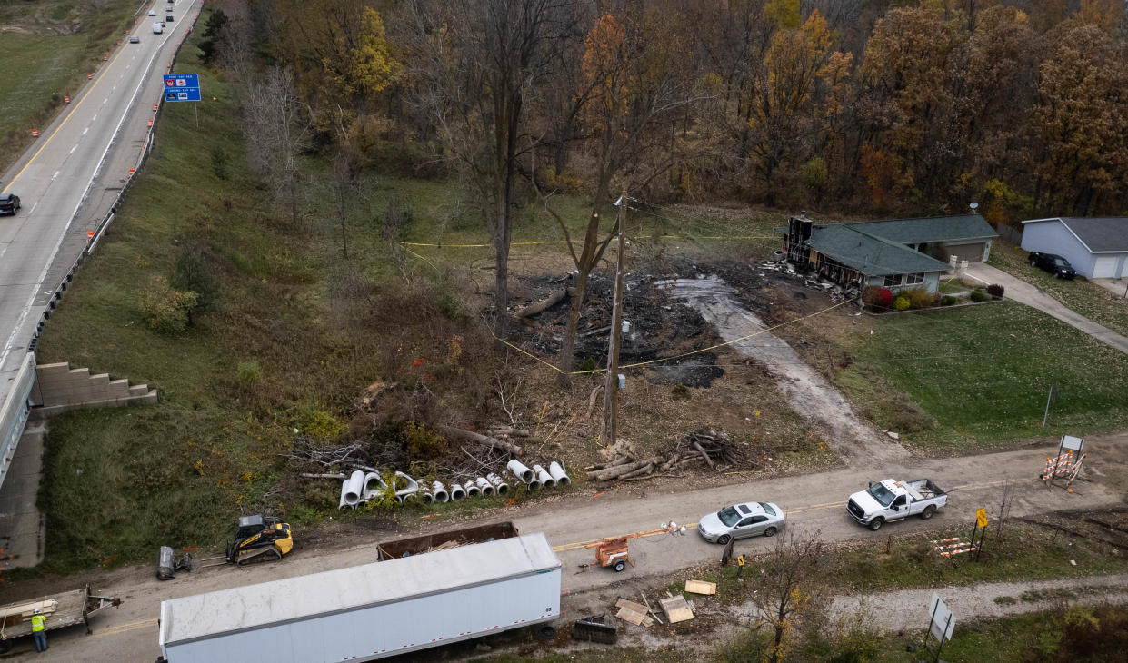 Ashes and caution tape surround the property where the "highway house" on Billwood Highway in Dimondale once stood near westbound I-96, pictured Wednesday, Oct. 25, 2023.