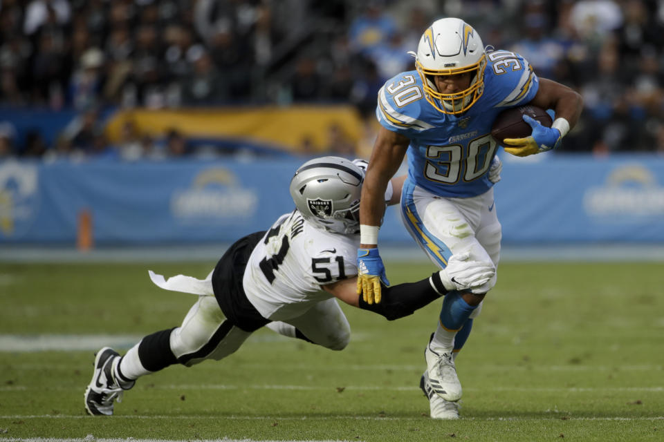 Los Angeles Chargers running back Austin Ekeler is tackled by Oakland Raiders inside linebacker Will Compton during the first half of an NFL football game Sunday, Dec. 22, 2019, in Carson, Calif. (AP Photo/Marcio Jose Sanchez)