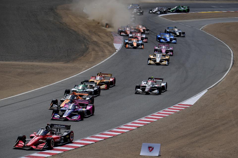 Sep 11, 2022; Salinas, California, USA; Team Penske driver Will Power (12) of Australia leads the field for the opening laps of the Grand Prix of Monterey at WeatherTech Raceway Laguna Seca. Mandatory Credit: Gary A. Vasquez-USA TODAY Sports