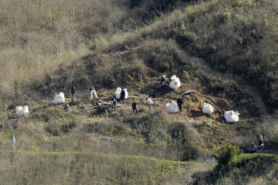 FILE - In this Tuesday, Jan. 28, 2020, file photo, investigators work at the scene of a helicopter crash that killed former NBA basketball player Kobe Bryant, his 13-year-old daughter, Gianna, and seven others, in Calabasas, Calif. Federal investigators say wreckage from the helicopter that crashed last month and killed Bryant, his daughter and seven others did not show any outward evidence of engine failure, the National Transportation Safety Board said Friday, Feb. 7, 2020. (AP Photo/Mark J. Terrill, File)