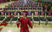 Paul Santiago Kelley, a graduating senior at Brophy College Preparatory, smiles as he takes a selfie as he celebrates Diploma Days with photos of all his fellow classmates after getting his diploma, due to the coronavirus Thursday, May 28, 2020, in Phoenix. The graduating Class of 2020 crossed the stage to graduate over a several-day period for social-distancing protocols. (AP Photo/Ross D. Franklin)