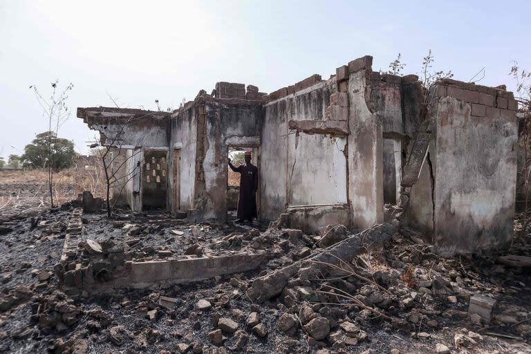 Esta fotografía tomada el 31 de marzo de 2024 muestra al subdirector Bature Sule inspeccionando los restos de un dormitorio destruido por combatientes de Boko Haram en la escuela secundaria pública para niñas de Chibok en 2014