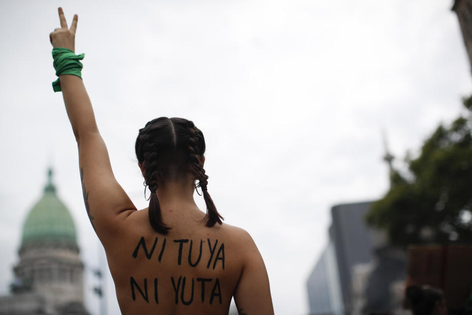 A woman makes the Victory sign in front of the Congress during a march to commemorate the International Women's Day in Buenos Aires, Argentina, Monday, March 9, 2020.(AP Photo/Natacha Pisarenko)