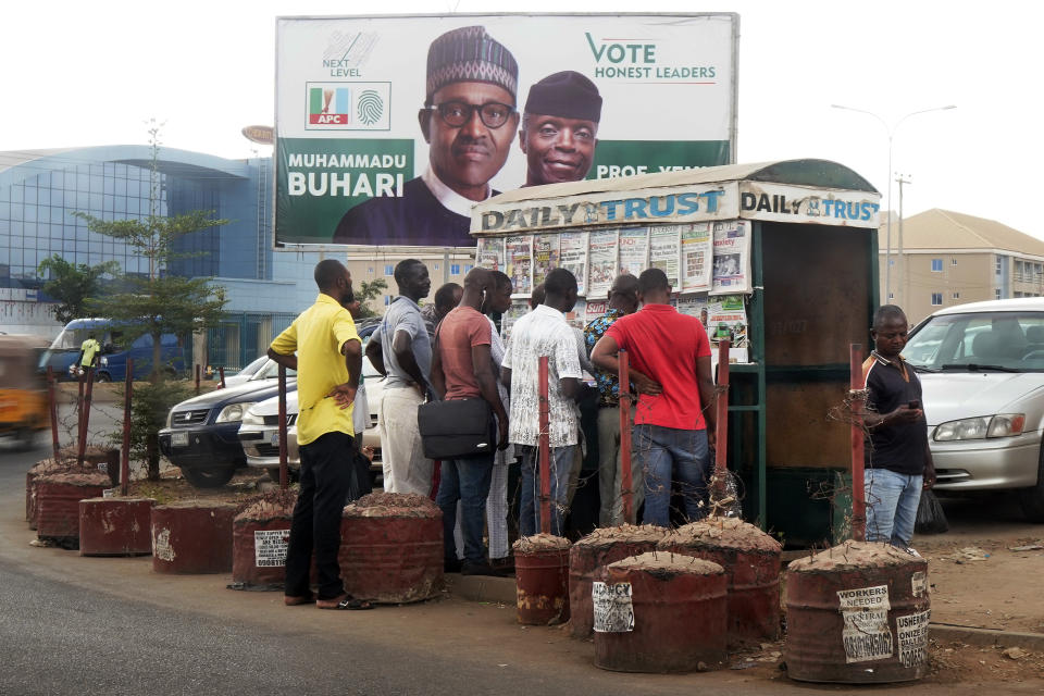 Nigerians read newspapers at a newsstand in Abuja, Nigeria, Monday Feb. 25, 2019. Official results of Nigeria's presidential election are expected as early as Monday in what is being seen as a close race between Incumbent President Muhammadu Buhari and opposition candidate Atiku Abubakar. (AP Photo/Jerome Delay)