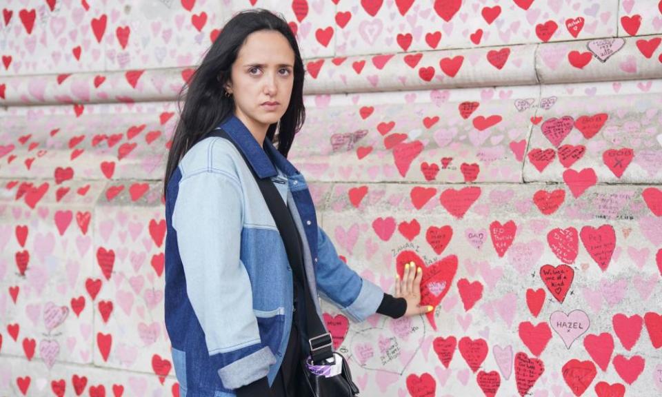 Safiah Ngah, who lost her father, Zahari, to coronavirus, with the heart she painted for him at the national Covid memorial wall in central London.