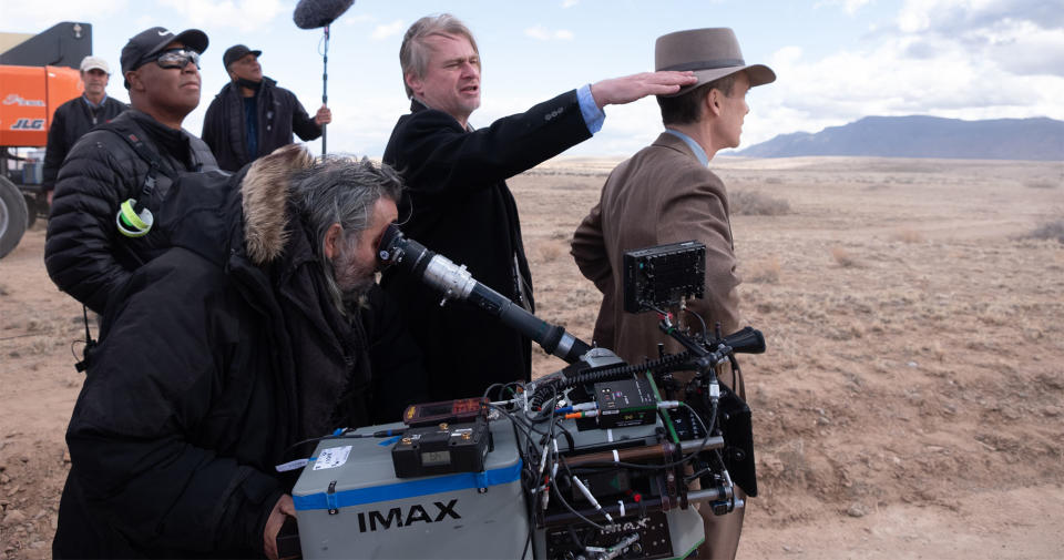 six people stand in a desert-grassland landscape with mountains in the background.