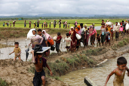 A group of Rohingya refugee people walk towards Bangladesh after crossing the Bangladesh-Myanmar border in Teknaf, Bangladesh. REUTERS/Mohammad Ponir Hossain