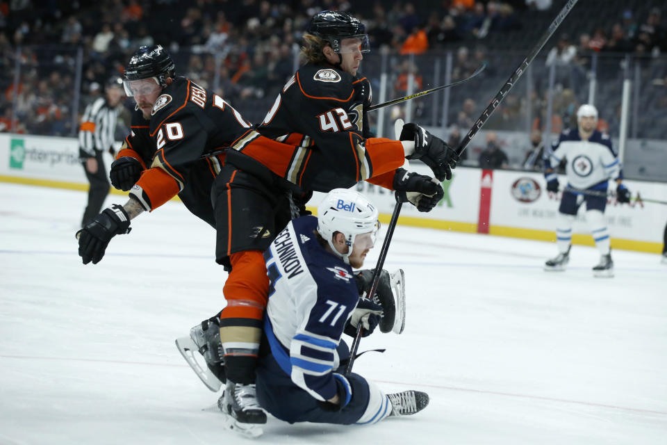 Winnipeg Jets left wing Evgeny Svechnikov (71) collides with Anaheim Ducks left wing Nicolas Deslauriers, left, and defenseman Josh Manson, above center, during the first period of an NHL hockey game in Anaheim, Calif., Tuesday, Oct. 26, 2021. (AP Photo/Alex Gallardo)