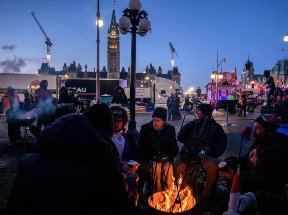 Demonstrators keep warm by lighting a fire outside Canada’s parliament (AFP via Getty Images)