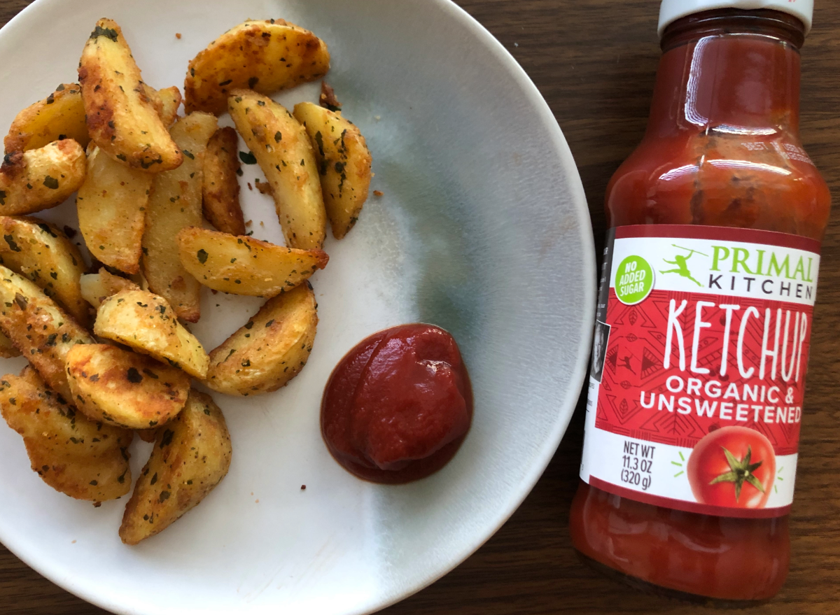 primal ketchup bottle with ketchup and fries on a plate.