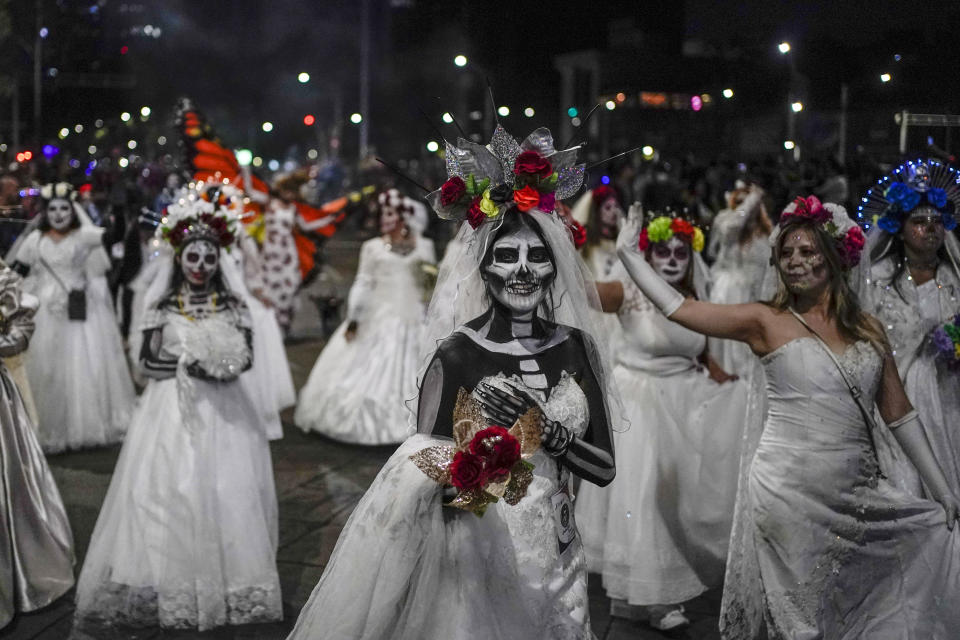 FILE - People dressed as Mexico's iconic "Catrinas" march in the Grand Procession of the Catrinas, part of upcoming Day of the Dead celebrations in Mexico City, Sunday, Oct. 23, 2022. Skeletal images have abounded in Mexico since pre-Hispanic times. But in 1910, when Mexico was living under the exclusionary policies of dictator Porfirio Díaz, illustrator Jose Guadalupe Posada sketched the image of La Catrina as a tool for social satire. The implication was that the extravagance of a few who were accumulating vast wealth was killing others. (AP Photo/Eduardo Verdugo, File)