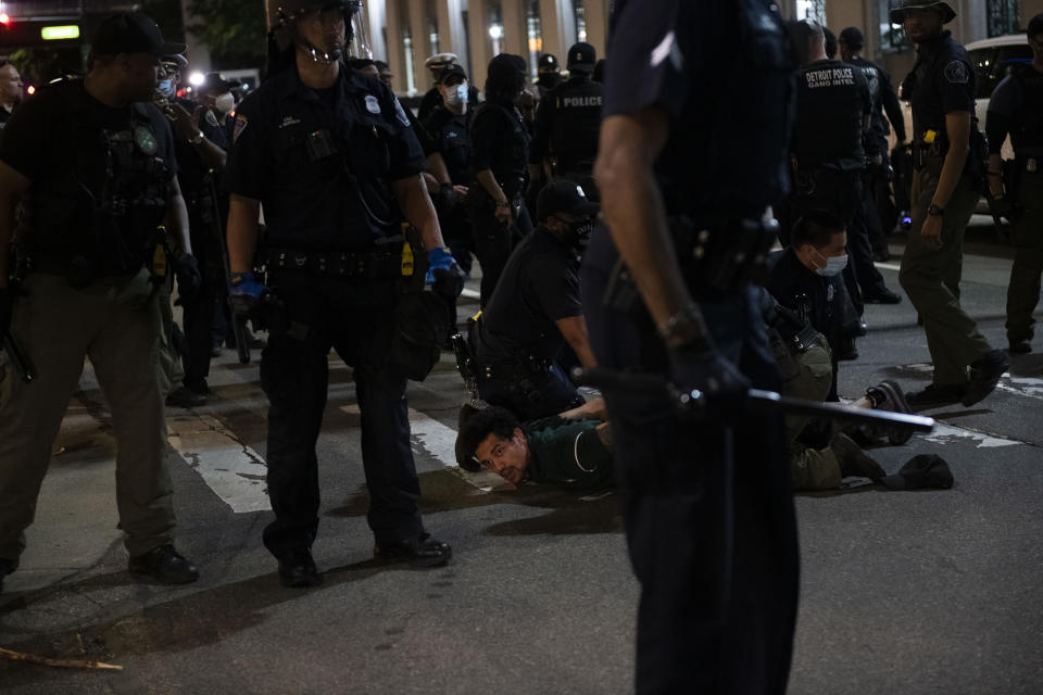 In this May 29, 2020, photo, a person is tackled by police during a rally calling for an end to police violence and justice for George Floyd in Detroit.. (Nicole Hester/Mlive.com/Ann Arbor News via AP)