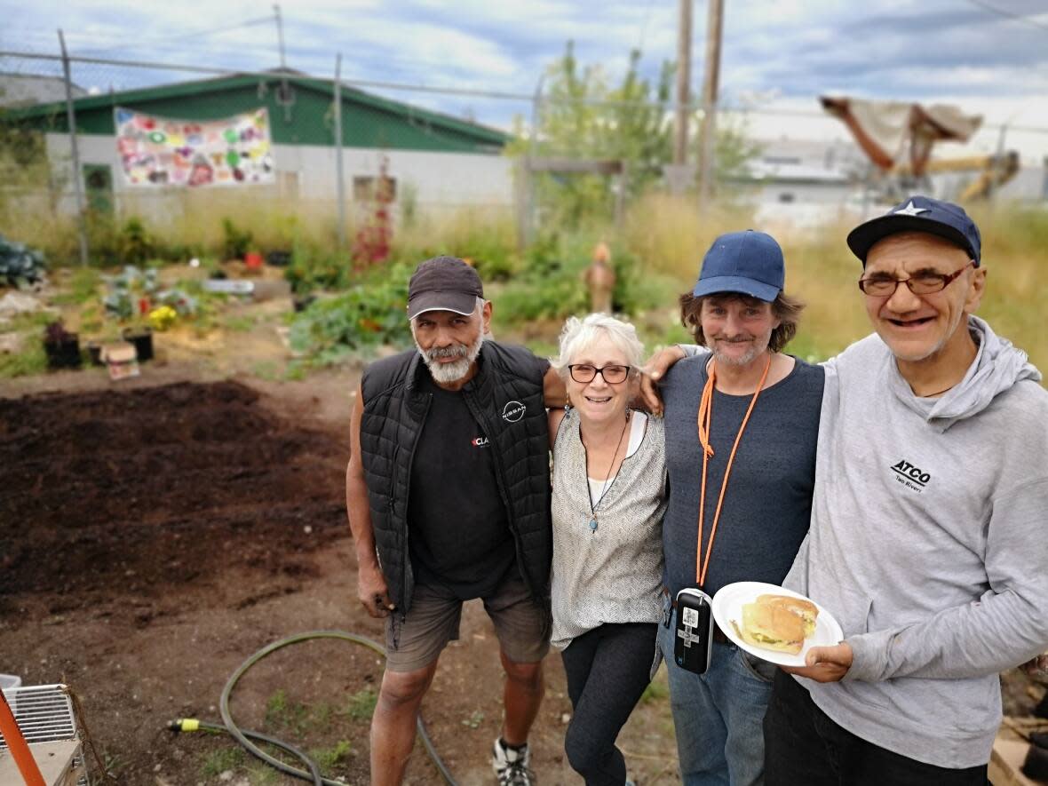 April Ottesen, second from left, started the Moccasin Flats garden which homeless residents, such as Jim Santos, far left, Jim Smith, centre, and Tim Bryce work on in downtown Prince George.  (Jason Peters/CBC News - image credit)