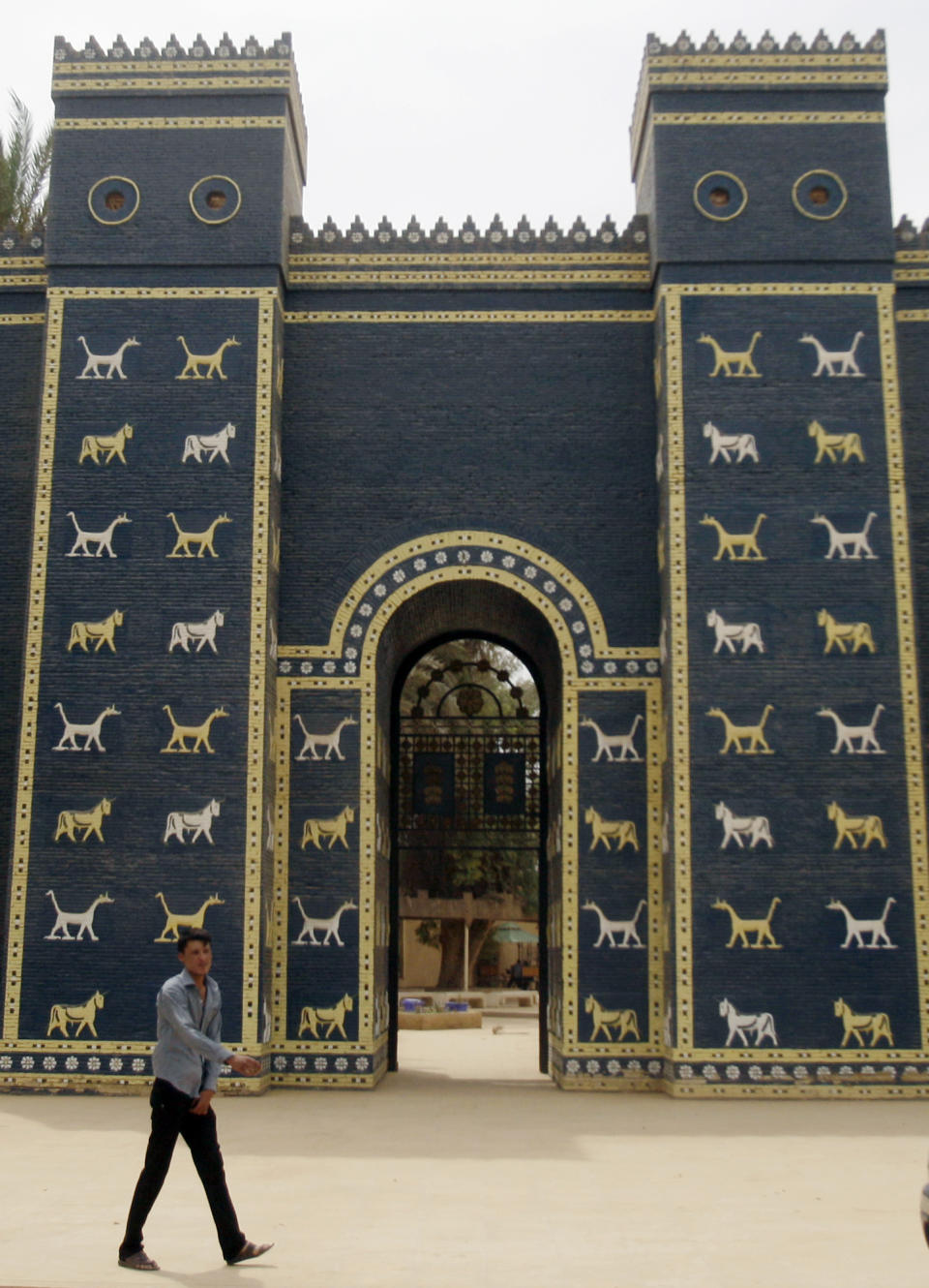 FILE - In this Sunday, May 6, 2012 file photo, a man walks in front of Ishtar Gate at the archaeological site of Babylon, Iraq. Iraq is celebrating UNESCO's World Heritage Committee's naming the historic city of Babylon a World Heritage Site in a vote in Azerbaijan. Friday, July 5, 2019 vote comes after Iraq bid for years for Babylon to become a World Heritage Site. (AP Photo/Khalid Mohammed, File)