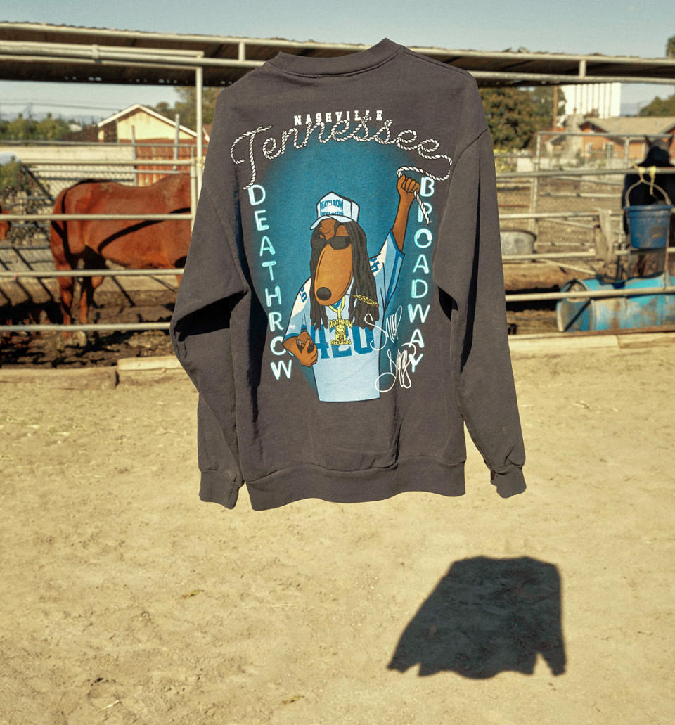 A shot of the crewneck from the Stevenson Ranch x Snoop Dogg collaboration floating in front of horses. 