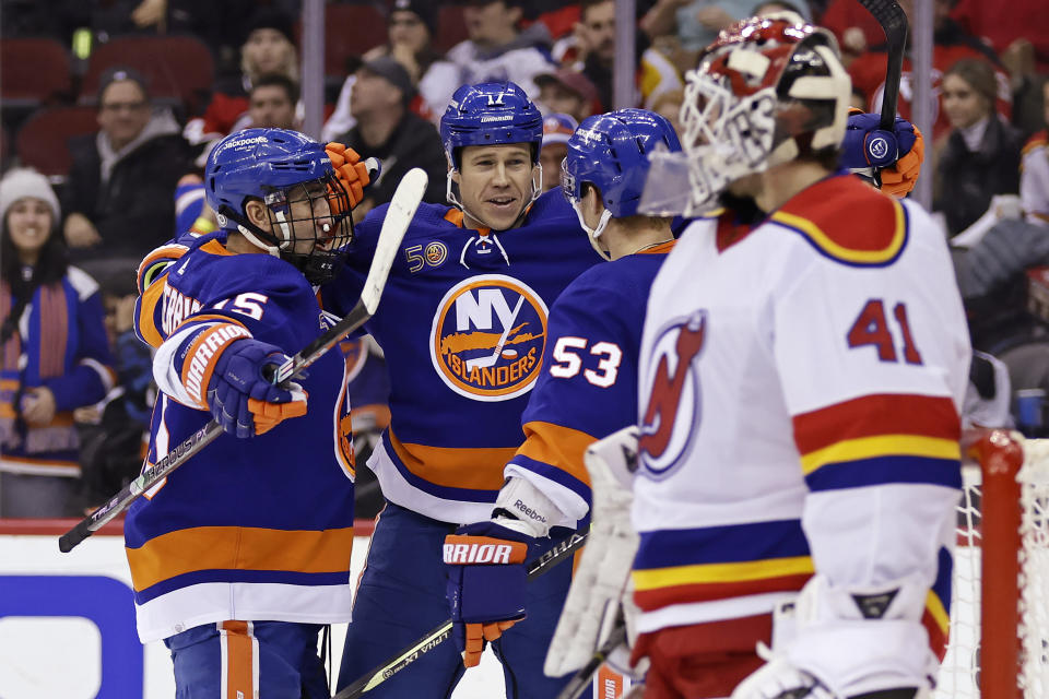 New York Islanders center Casey Cizikas (53) is congratulated by Matt Martin (17) and Cal Clutterbuck after scoring agianst New Jersey Devils goaltender Vitek Vanecek during the second period of an NHL hockey game Friday, Dec. 9, 2022, in Newark, N.J. (AP Photo/Adam Hunger)