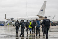 In this photo released by Australian Department of Defense, Australian Federal Police Special Operations members prepare to depart Canberra, Australia, for the Solomon Islands on a Royal Australian Air Force jet, Thursday, Nov. 25, 2021. Australia says it is sending police, troops and diplomats to the Solomon Islands to help after anti-government demonstrators defied lockdown orders and took to the streets for a second day in violent protests. (LACW Jacqueline Forrester/Australian Department of Defense via AP)