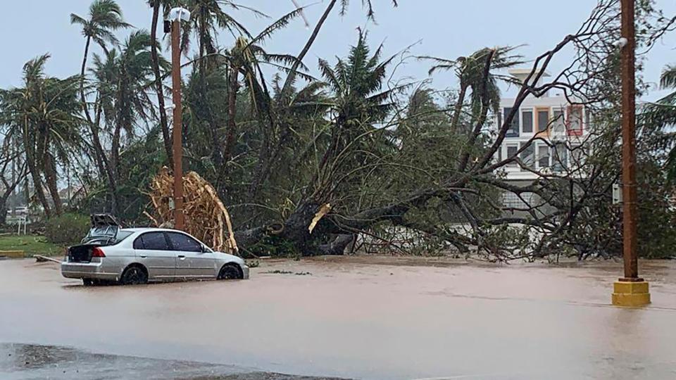 The waters of the Hagatna River overflows its banks and encroaches into the Bank of Guam parking lot in Hagatna (AP)