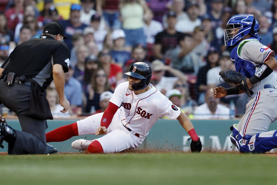 Boston Red Sox's Enrique Hernandez, center, scores on a fielder's choice single by Xander Bogaerts after a missed catch error by Texas Rangers' Meibrys Viloria, right, during the fifth inning of a baseball game, Saturday, Sept. 3, 2022, in Boston. (AP Photo/Michael Dwyer)