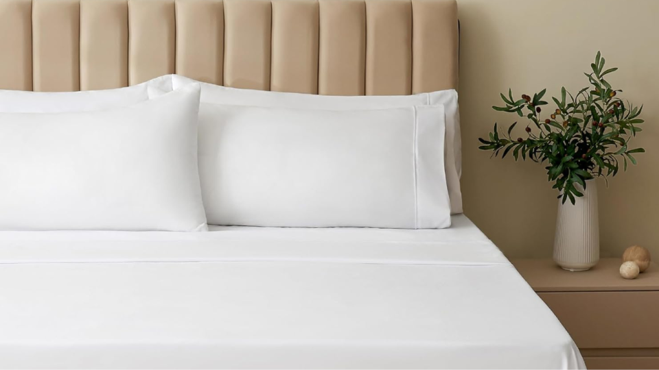 the white bamboo sheets and pillowcases on a made bed