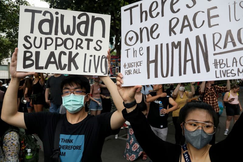 People hold posters supporting the Black Lives Matter movement in Taipei