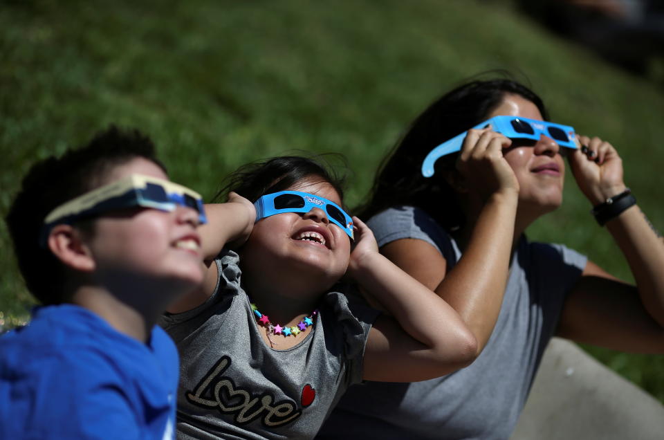 La gente observa un eclipse solar sobre América del Sur, visible en partes de Chile y Argentina, en Buenos Aires, Argentina, el 14 de diciembre de 2020. (REUTERS/Agustin Marcarian)