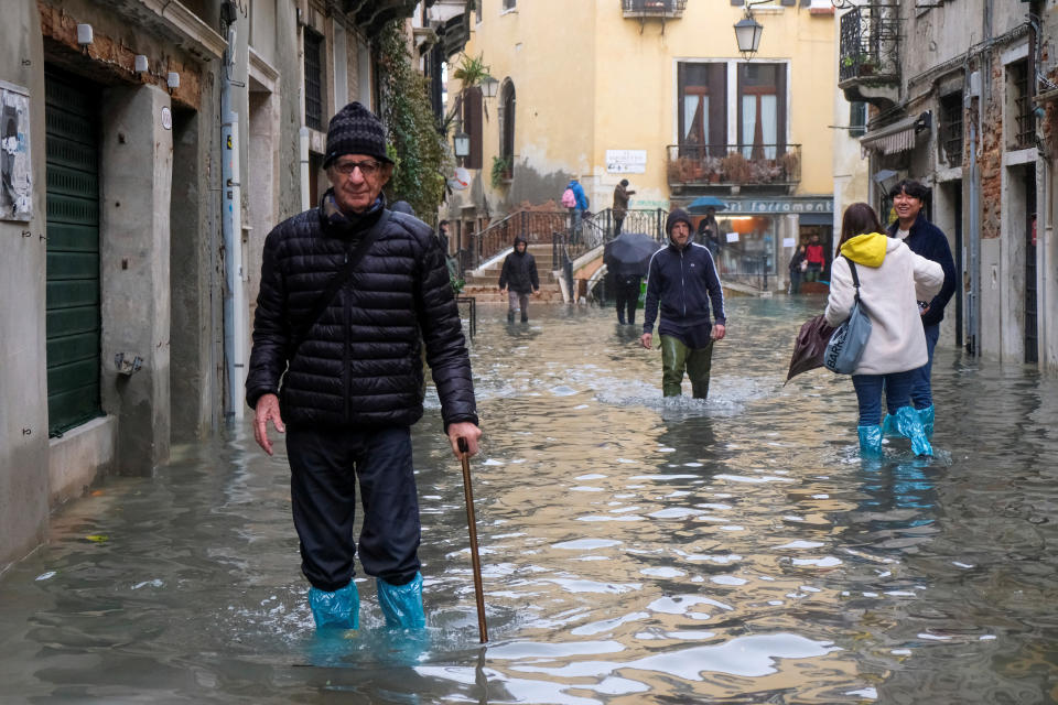 People walk outside during an exceptionally high water levels in Venice, Italy November 13, 2019. REUTERS/Manuel Silvestri