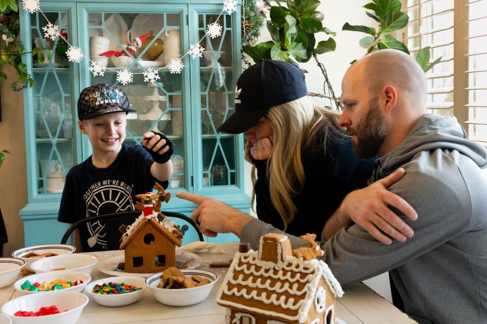 Zeke Priday, 8, left, shows off his gingerbread house to his parents Kali and Darin at their home in Saratoga Springs on Sunday, Dec. 3, 2023. | Megan Nielsen, Deseret News