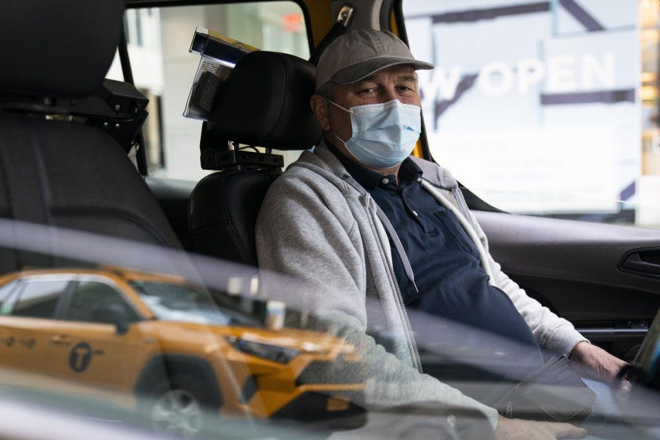 Nicolae Hent sits for a portrait in his taxi outside a midtown Manhattan hotel, in New York on March 19, 2021. A year ago, The Associated Press told the story of a day in the life of a stricken city through the eyes of New Yorkers on the front lines and in quarantine as they faced fear, tragedy, isolation and upheaval. “Not an easy year to go through in 2020," Hent said. "Hopefully, this one will be better, but God knows.” (AP Photo/John Minchillo)