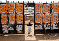 <p>A child plays at the entrance of a polling station pasted with campaign posters in Sarang’ombe ward ahead of the Presidential election at the Kisumu Ndogo village in Kibera slums of Nairobi, Kenya, Aug. 6, 2017. (Photo: Thomas Mukoya/Reuters) </p>