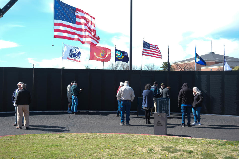 Attendees look over the names on the wall at the opening ceremony for the Vietnam Traveling Memorial Wall Wednesday at the Ussery-Roan Texas State Veterans Home in Amarillo.