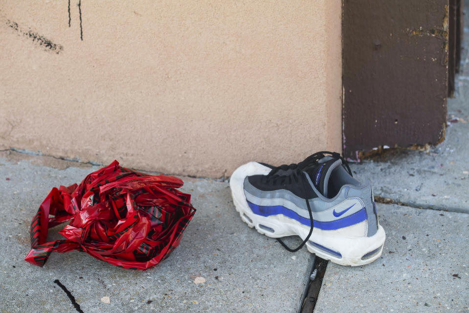 In this Saturday, June 29, 2019, photo, a shoe rests near balled-up crime scene tape outside the Stadium Ultralounge & Bar, where multiple people were injured in a shooting earlier in the day, in Baton Rouge, La. (Travis Spradling/The Advocate via AP)