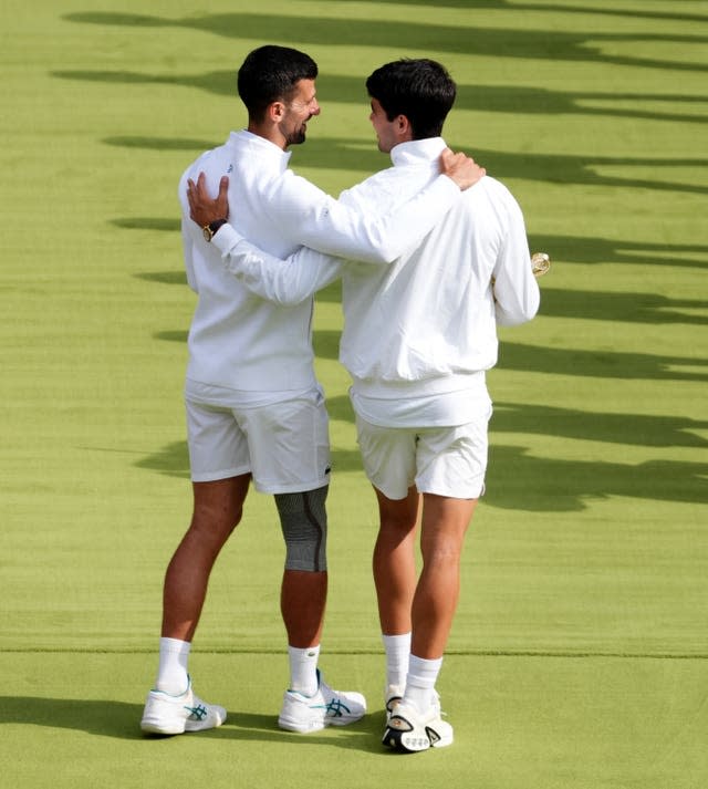 Carlos Alcaraz, right, embraces Novak Djokovic