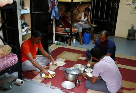 Asian workers have their lunch at their accommodation in Qadisiya labour camp, Saudi Arabia August 17, 2016. Picture taken August 17, 2016. REUTERS/Faisal Al Nasser