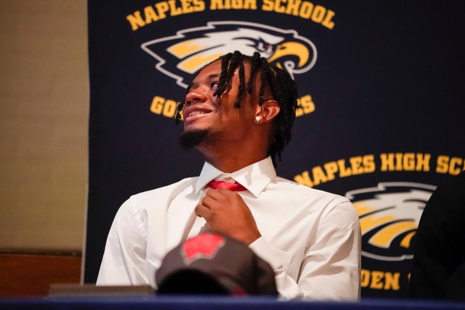 Naples cornerback Jonas Duclona smiles while watching highlights during an early signing celebration at Naples High School in Naples on Thursday, Dec. 15, 2022. 