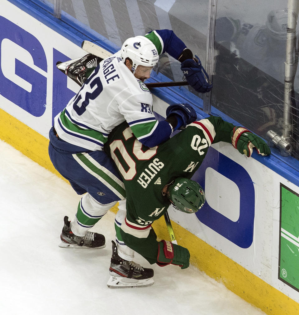 Minnesota Wild's Ryan Suter (20) is checked by Vancouver Canucks' Jay Beagle (83) during the first period in an NHL hockey game in Edmonton, Alberta, Thursday Aug. 6, 2020. (Jason Franson/The Canadian Press via AP)