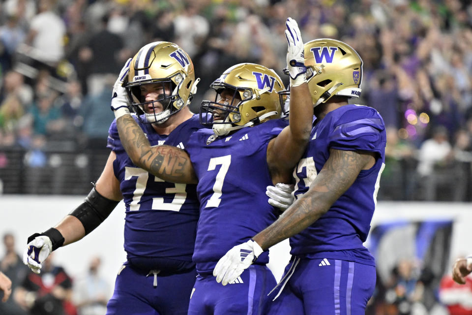 Washington running back Dillon Johnson (7) celebrates with teammates after a touchdown against Oregon during the second half of the Pac-12 championship NCAA college football game Friday, Dec. 1, 2023, in Las Vegas. (AP Photo/David Becker)