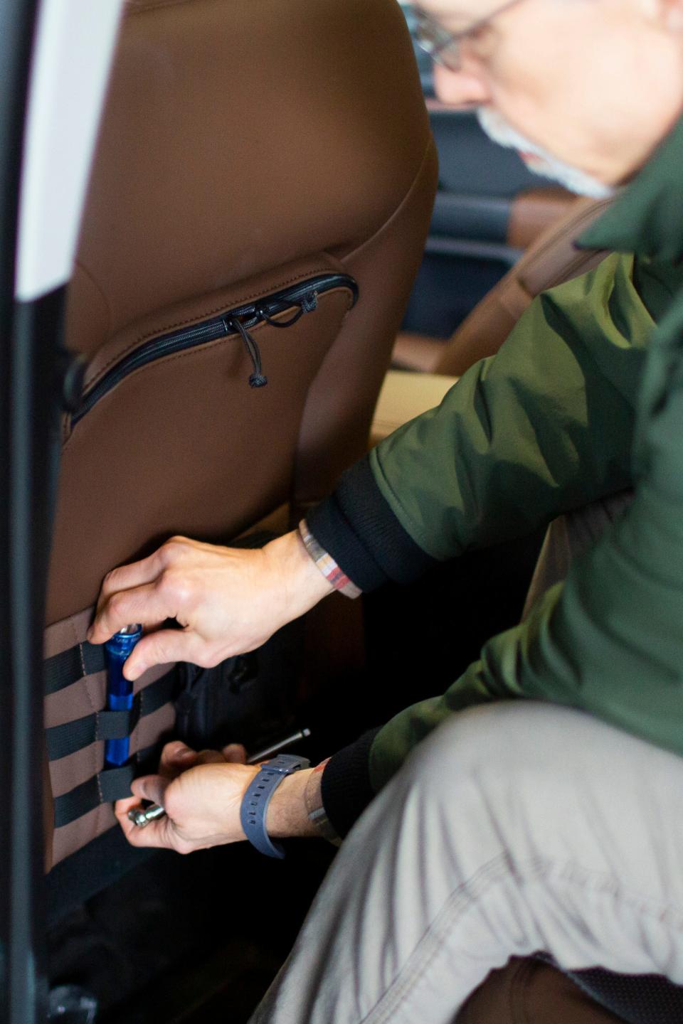 John Carl Faust, an ergonomics engineer formerly with a defense industry supplier General Dynamics,  is shown here Feb. 22, 2021 in Dearborn demonstrating how the unique storage straps work in the 2021 Ford Bronco Sport. His name is on the patent.