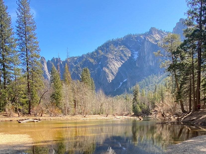 Mountains and trees surround a small body of water at Yosemite National Park.