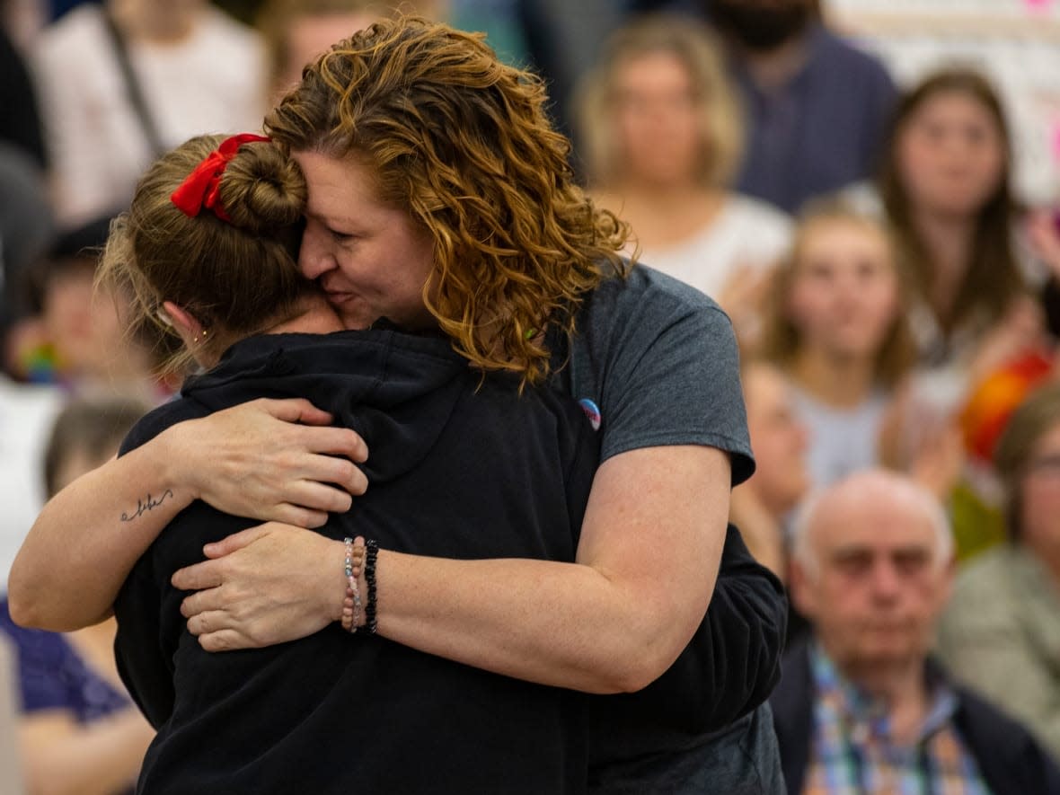 An audience member embraces Penni Jones, left, who spoke against banning books at a Brandon School Division board of trustees meeting at Vincent Massey High School on Tuesday, May 23, 2023. (Chelsea Kemp/CBC - image credit)