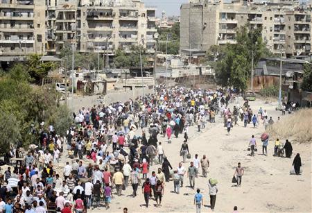 A view is seen of civilians as they walk at the Karaj al-Hajez crossing, a passageway separating Aleppo's Bustan al-Qasr, which is under the rebels' control and Al-Masharqa neighborhood, an area controlled by the regime, September 10, 2013. REUTERS/Ammar Abdullah