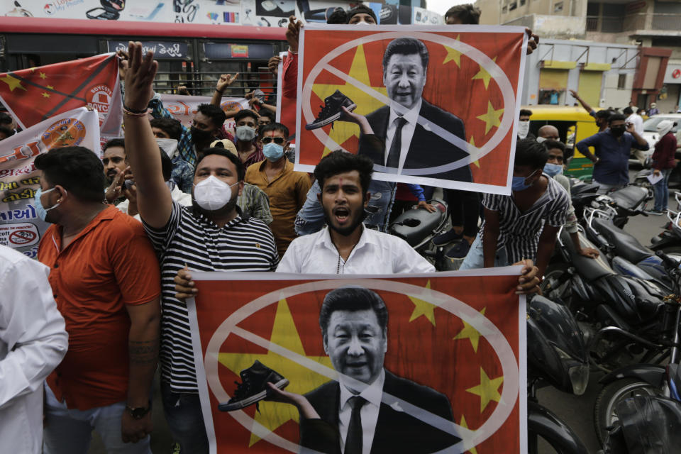 Karni Sena supporters hold banners featuring Chinese President Xi Jinping and shout slogans during a protest against China in Ahmedabad, India, Wednesday, June 24, 2020. Chinese and Indian military commanders have agreed to disengage their forces in a disputed area of the Himalayas following a clash that left at least 20 soldiers dead, both countries said Tuesday. The commanders reached the agreement Monday in their first meeting since the June 15 confrontation, the countries said. (AP Photo/Ajit Solanki)