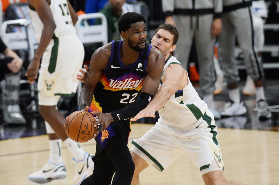 Phoenix Suns center Deandre Ayton (22) looks to pass the ball as Milwaukee Bucks center Brook Lopez (11) defends in the first half during Game 5 of the NBA Finals.