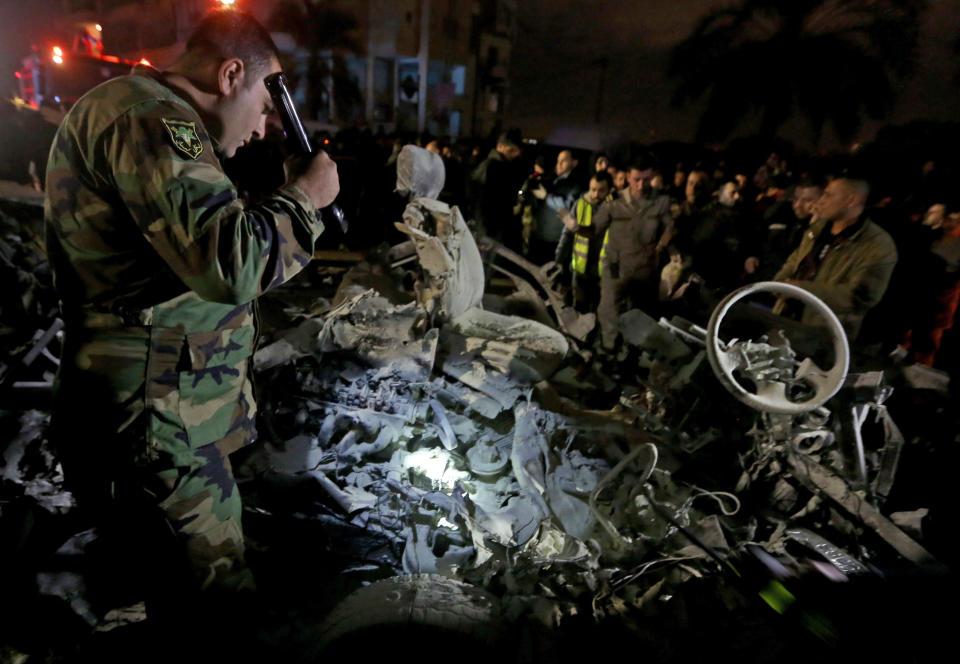 A Lebanese army solider inspects the damages of a vehicle after a suicide bomber blew himself up in a passenger van in the Choueifat district southern Beirut, Lebanon, Monday, Feb. 3, 2014. A suicide bomber blew himself up in the southern suburbs of the Lebanese capital Monday, wounding at least six people, the state news agency said. The blast, which took place during the evening rush hour in the Choueifat district, appeared to be the latest of a string of attacks in Lebanon linked to the civil war in neighboring Syria. The conflict has deeply divided Lebanon along sectarian lines and helped fuel a surge in violence that has rattled the already fragile country. (AP Photo/Bilal Hussein)