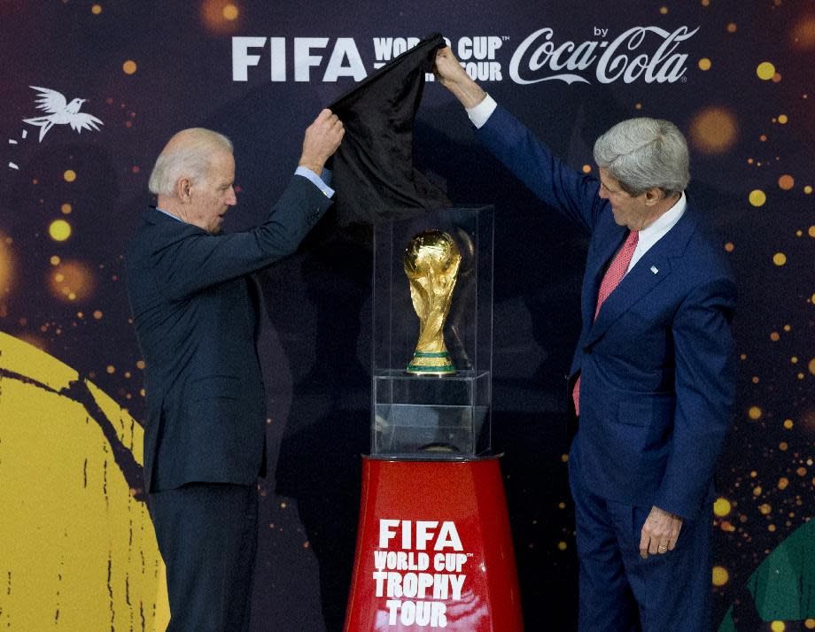 Vice President Joe Biden, left, and Secretary of State John Kerry, unveil the FIFA World Cup trophy, the actual trophy that will be awarded to the winner of this year’s World Cup soccer tournament in Brazil, Monday, April 14, 2014, during a ceremony at the State Department in Washington. (AP Photo/Manuel Balce Ceneta)