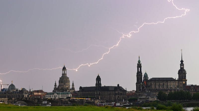 Lightning can be seen during a thunderstorm in the sky over the old city with the dome of the Academy of Fine Arts with the angel "Fame" (LR), the Frauenkirche, the Staendehaus, the Hofkirche, the Town Hall and the Hausmannsturm.  Robert Michael/dpa