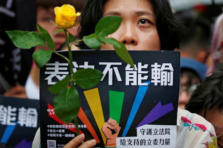 A same-sex marriage supporter holds rose to mourn those who committed suicide due to discrimination during a parliament vote on three draft bills of a same-sex marriage law, outside the Legislative Yuan in Taipei, Taiwan May 17, 2019. REUTERS/Tyrone Siu