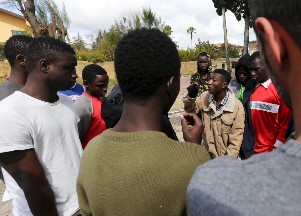 Adolescent migrants argue during a protest in a courtyard at an immigration centre in Caltagirone, Sicily March 18, 2015. The migrants claim they are staying in the centre longer than a duration of three months, as promised to them. The number of migrants reaching Italy by sea this year is set to top last year's record of 170,000, the International Organization for Migration (IOM) said. In the past week alone 10,000 have arrived. Another 400 people drowned before making it to Italy's shores, survivors said. The number of minors traveling alone in this mass migration has soared -- underage arrivals to Italy tripled in 2014 from the previous year. Picture taken March 18, 2015. To match Insight ITALY-MIGRANTS/BOYS REUTERS/Alessandro Bianchi