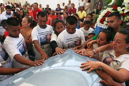 Relatives and friends of Antonio Zambrano-Montes touch his coffin during a funeral mass in Pomaro, in the Mexican state of Michoacan March 7, 2015. Zambrano-Montes, 35, an unemployed orchard worker from Mexico's Michoacan state, was killed in February in Pasco, a city of 68,000 residents in Washington state's agricultural heartland. REUTERS/Alan Ortega/File Photo